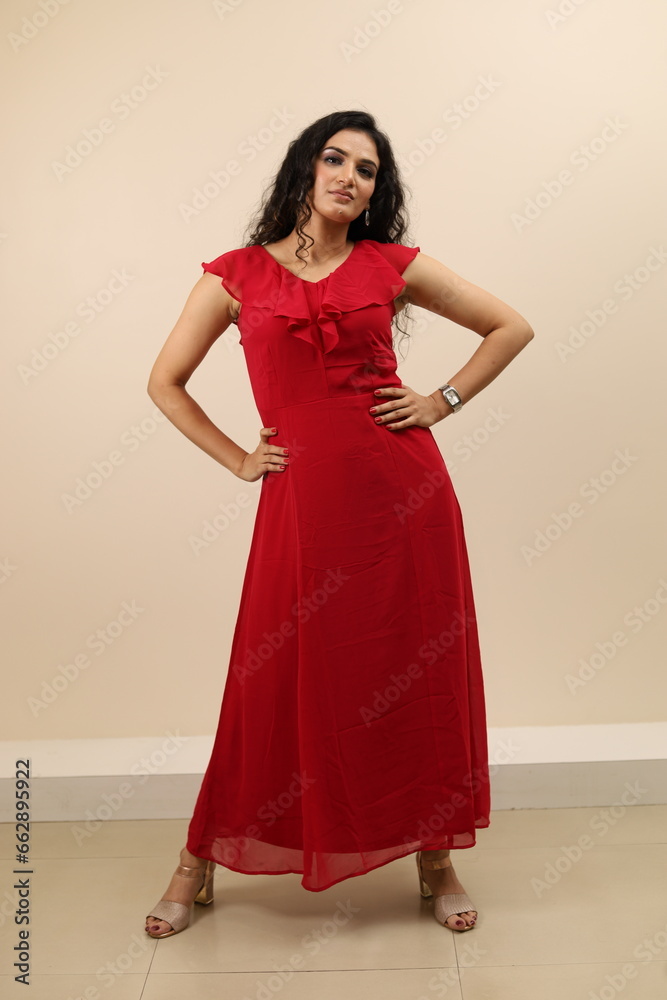 Fototapeta premium Lady flaunting. Beautiful portrait of a confident, sexy young lady in red gown flaunting and wearing eyewear.