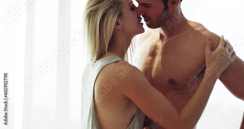 Home, kiss and couple with love, intimacy and romance with relationship, bonding together and honeymoon. People, bedroom or man with woman, erotic and happiness with anniversary, marriage or romantic