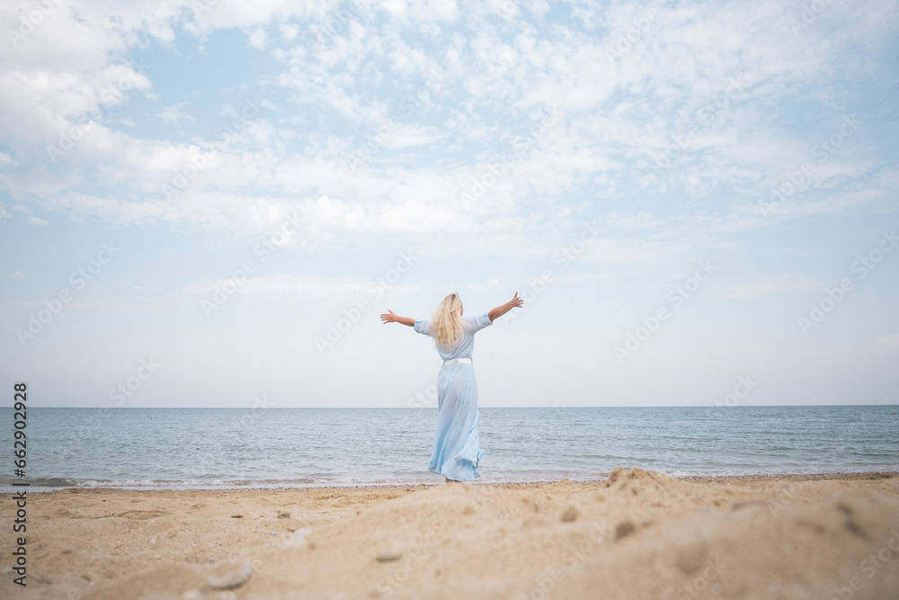 sea, sky, clouds, sunset, ocean, blonde woman in a floating dress stands with her back to the viewer, blue, without face, horizontal, photo sea, sky, clouds, sunset, ocean, blonde woman in a floating dress stands with her back to the viewer, blue, without face, horizontal, photo