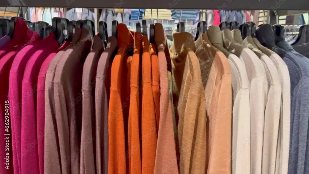 Shopping mall boutique filled with fashion tailoring, multiple racks with fashionable formal wear. Empty clothing showroom with trendy shirts on hangers, small business concept. Buying clothes. High