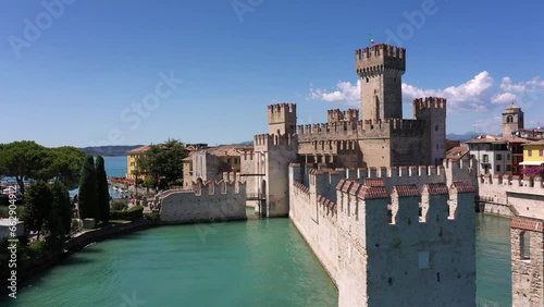The historical part of the city of Sirmione on Lake Garda in Italy, slow motion shot by drone. Scaliger Castle of the city of Sirmione 4K video on drone. Sirmione drone view, close angle. photo