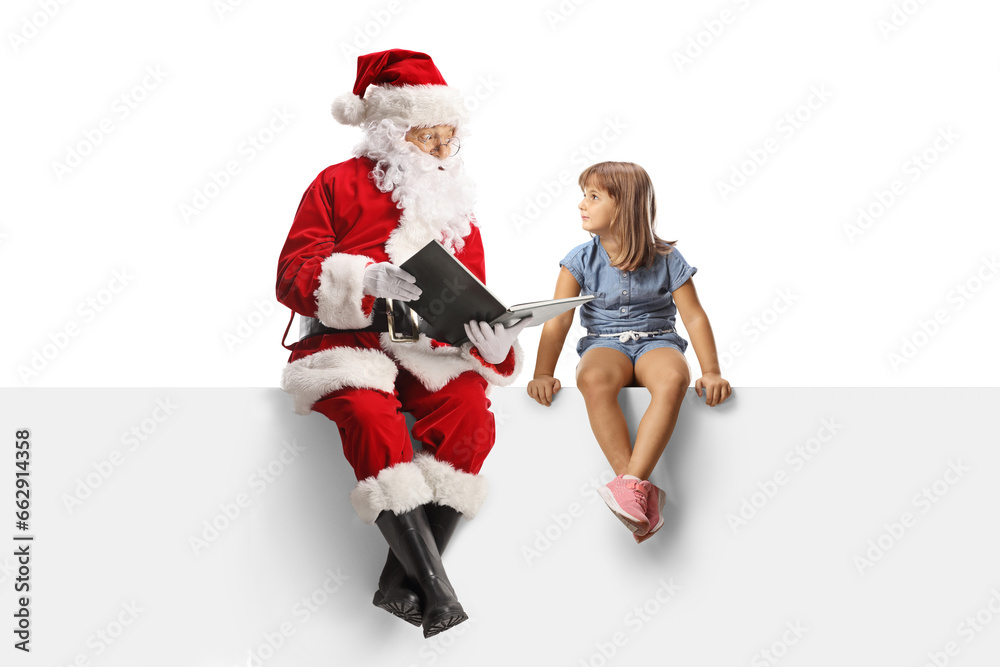 Santa claus sitting on a blank panel and reading a story to a little girl Santa claus sitting on a blank panel and reading a story to a little girl