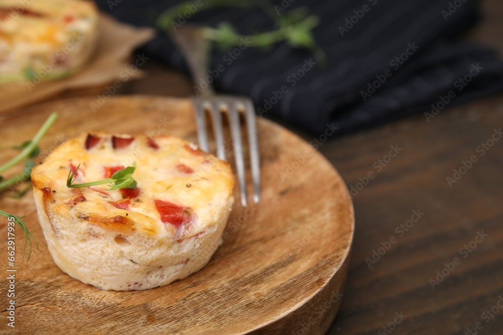Delicious egg muffin with cheese and bacon on wooden table, closeup. Space for text Delicious egg muffin with cheese and bacon on wooden table, closeup. Space for text
