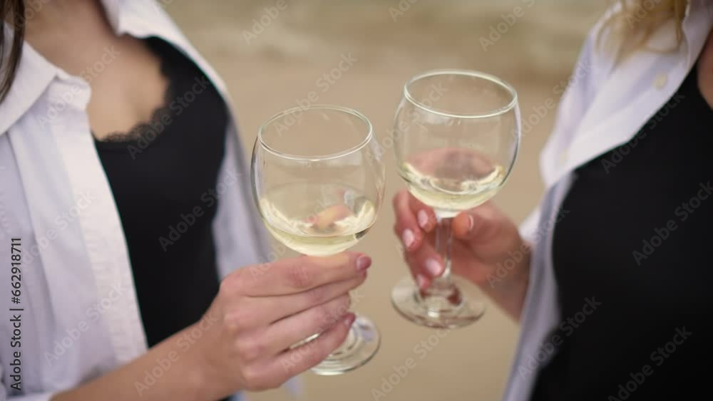 Two unrecognizable LGBT woman with wine glasses on ocean waves background celebrating marriage and honeymoon. Lesbian relations and love concept Two unrecognizable LGBT woman with wine glasses on ocean waves background celebrating marriage and honeymoon. Lesbian relations and love concept