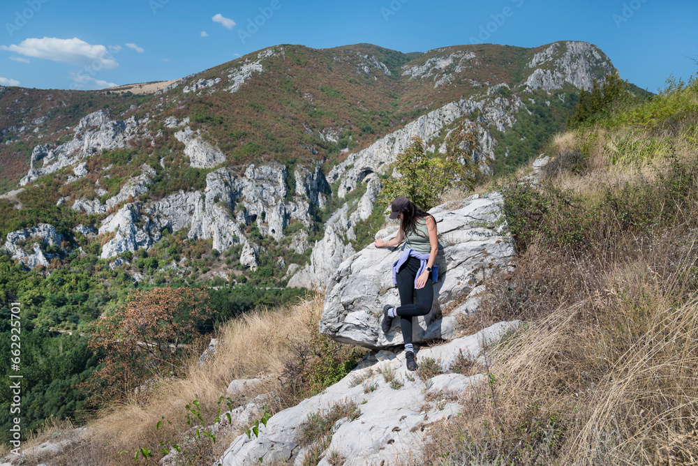Woman standing in the  summer mountain with stunning view 