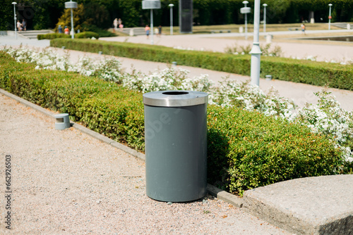 Public metal gray trash can in Park on city street outdoors. Help to reduce waste, Help global warming. High quality photo