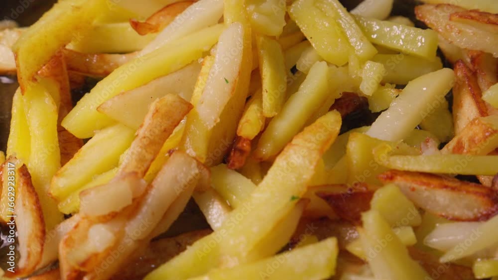 Potato pieces are fried in oil in frying pan. Potato pieces are fried in oil in frying pan.
