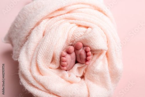 Little baby arms and legs.Baby in a basket on faux fur pink, soft focus  © Svetlana