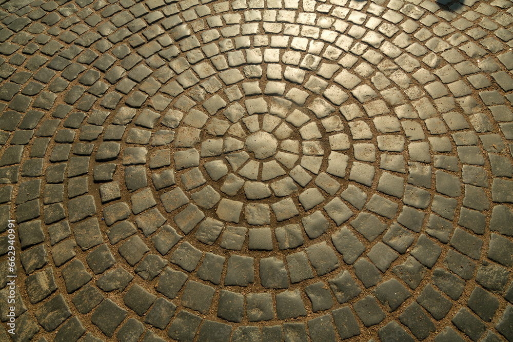 The pavement is paved with stones in the shape of a circle.