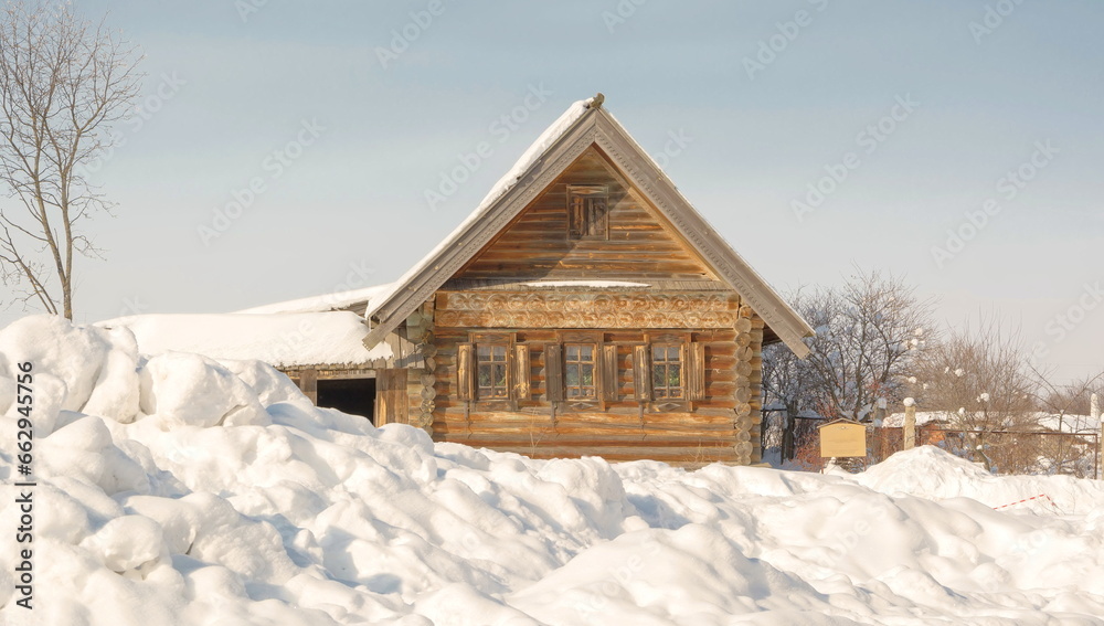 Log hut on a snow-covered village street