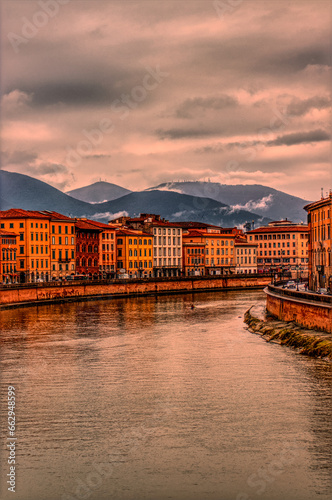 Pisa Lungarno under a dramatic sky, Italy.