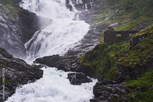 One of most famous south norwegian tourist attraction, the Kjosfossen waterfall with ruined stone house. Mystic and pitoresque place in in Aurland region of Norway, very popular to visit in summer. photo