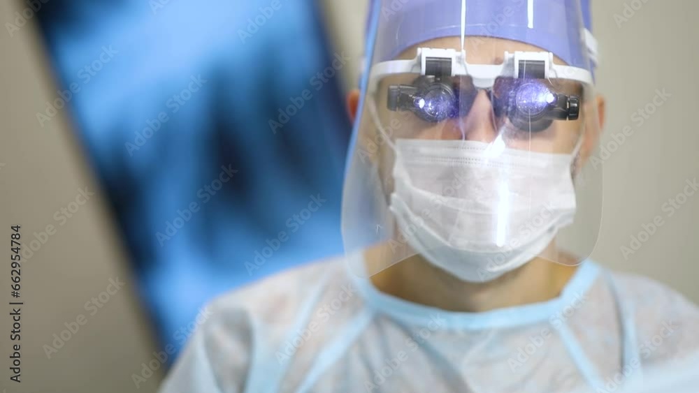 male surgeon in microsurgical glasses and protective reading in the operating room. Equipment for surgical operations. male surgeon in microsurgical glasses and protective reading in the operating room. Equipment for surgical operations.