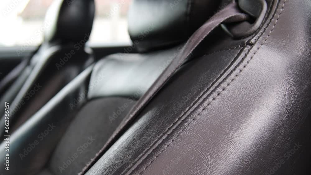 black leather upholstery in the interior of a luxury car, business class seams. black leather upholstery in the interior of a luxury car, business class seams.