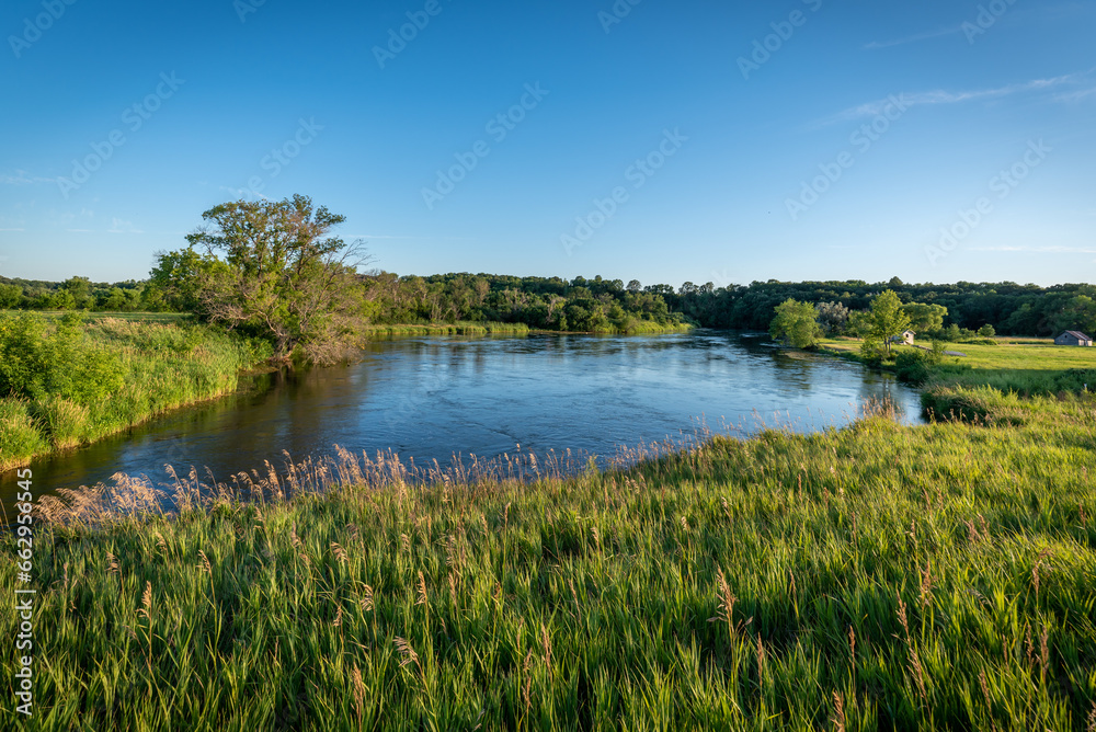 A body of water with trees and blue skies in the summer in rural Minnesota, USA.
A body of water with trees and blue skies in the summer in rural Minnesota, USA.