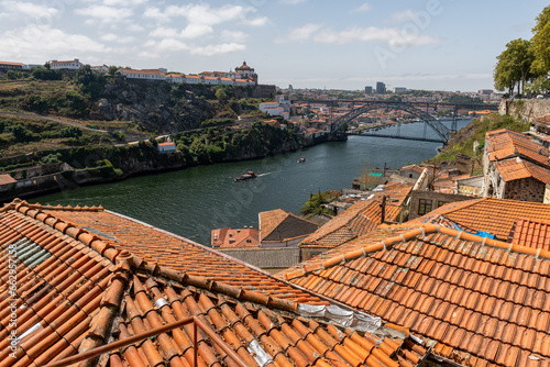 Widok na dachami z pomarańczowymi dachami na rzekę Duero oraz słynny most Ponte Dom Luís w Porto, stolicy Portugalii w Europie photo