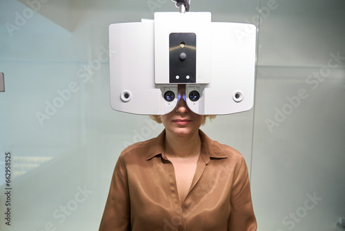 Lady in a brown blouse undergoes an ophthalmological examination