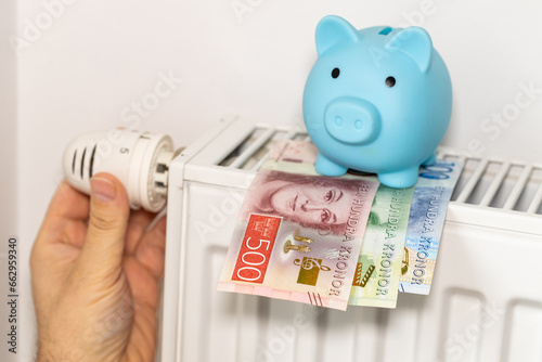 costs of heating apartments in winter in Sweden, Energy and economic concept, Hand unscrewing the radiator, piggy bank and Swedish krona