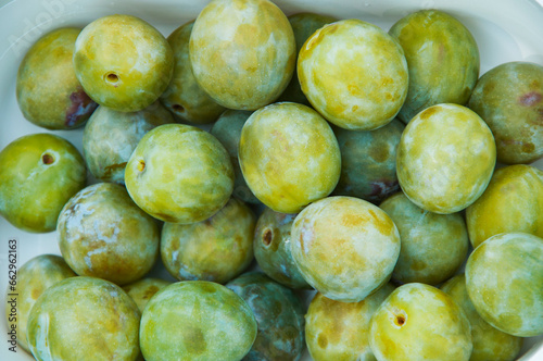 white sweet plums on the table. honey plum on a plate