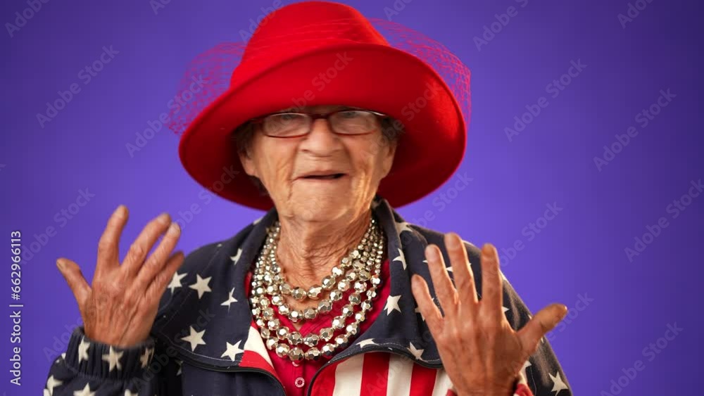 Closeup of puzzled, shocked, funny crazy toothless grandmother mature woman, 80s, acting wearing US flag jacket isolated on purple background. Concept of concern winner. Closeup of puzzled, shocked, funny crazy toothless grandmother mature woman, 80s, acting wearing US flag jacket isolated on purple background. Concept of concern winner.