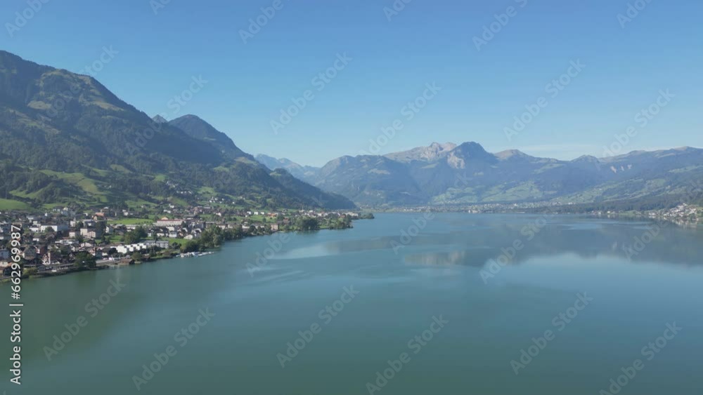 An overlook of a pristine lake and villages on the coastline between the Swiss mountains. An overlook of a pristine lake and villages on the coastline between the Swiss mountains.