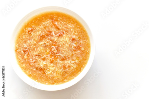 Tomato egg drop soup in a white bowl. Traditional Chinese food. Flat lay top view photo. Food from above concept.