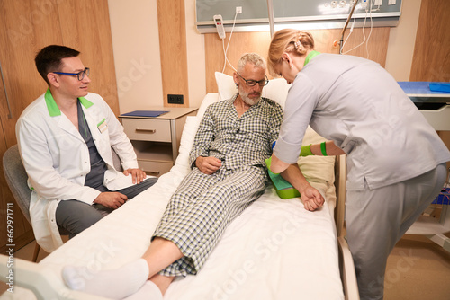 Nurse gives an injection into vein of gray-haired old man