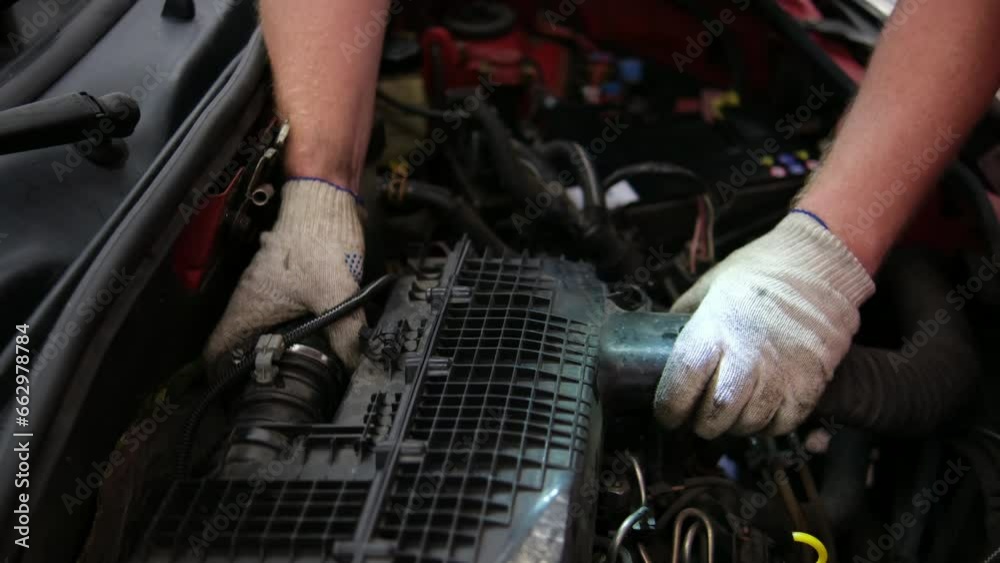 A Man with glasses Maintains an auto in a Garage. Auto Repair by an experienced Specialist in a vehicle Repair Shop. Replacing the oil and filter in the automobile. 4K video. A Man with glasses Maintains an auto in a Garage. Auto Repair by an experienced Specialist in a vehicle Repair Shop. Replacing the oil and filter in the automobile. 4K video.
