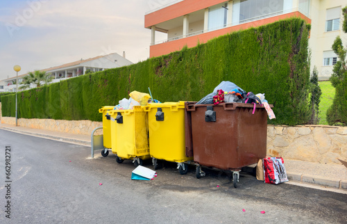 Dumpster for Garbage and food waste on city Spain street. Plastic litter, packaging waste in garbage container. Trash and Household waste. Overcrowded garbage. Sorting, Full bins with Empty soda cans.