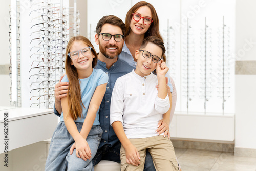Portrait of young happy family wearing stylish eyeglasses sitting in  optical store. Vision concept 