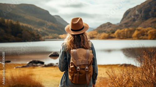 Tourist Woman with Hat and Backpack in Scotland. Wanderlust concept. photo