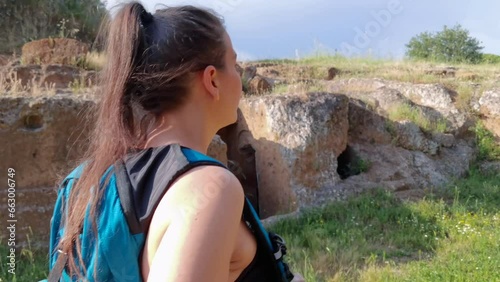 A girl walks in the green of the Etruscan cemetery