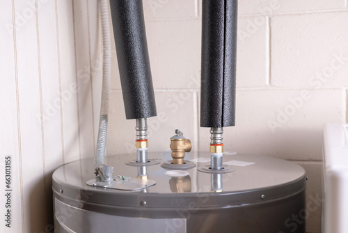 Pipe insulation. Water heater pipes covered with foam insulation
