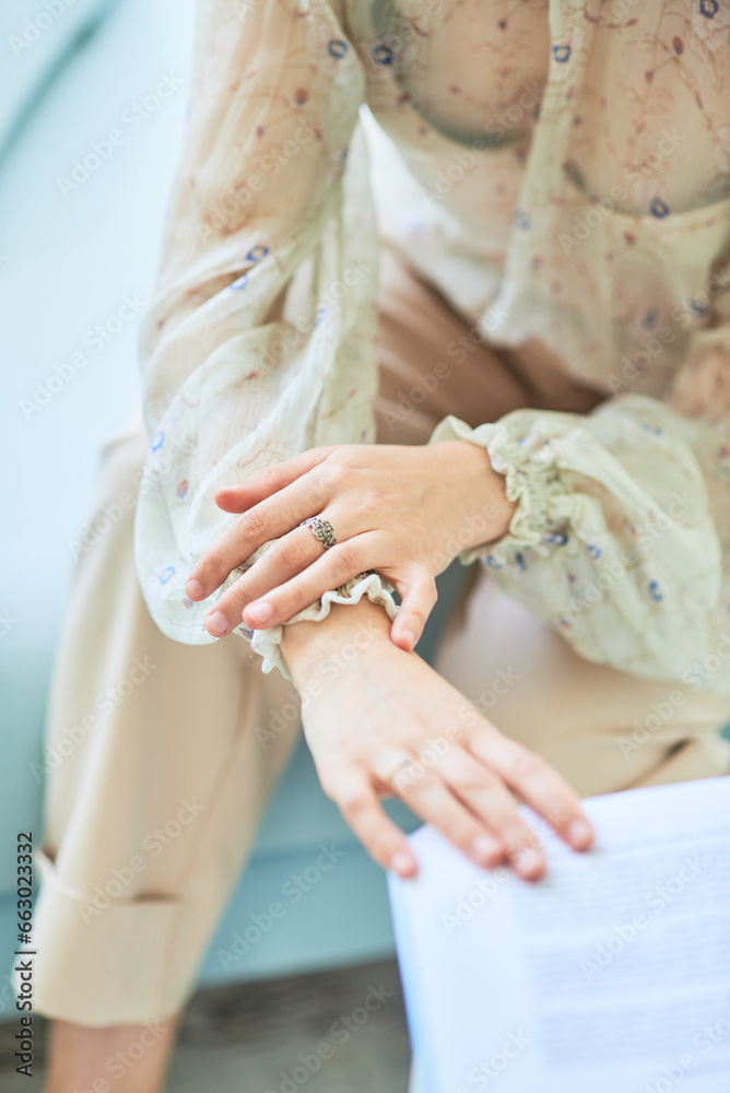 Obraz premium Women's beautiful hands. Touching the pages of an open book with your fingers. Beige tones of photography. Close-up. Defocused background.