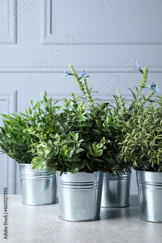 Different artificial potted herbs on light table © New Africa