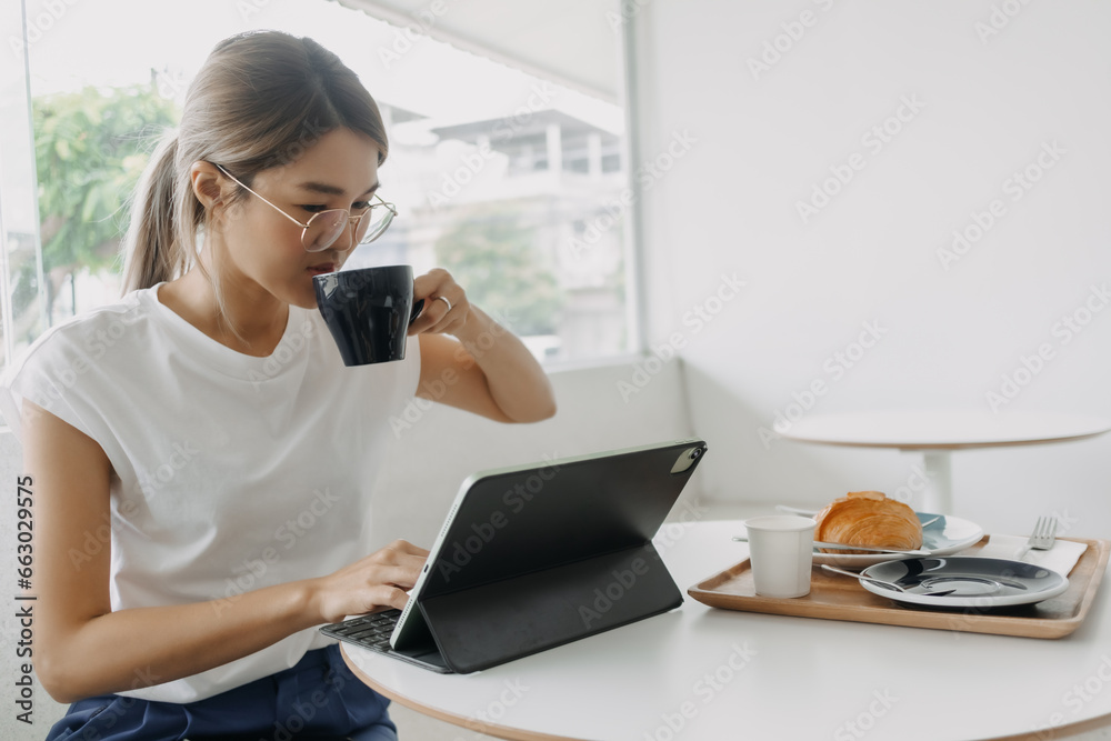 Happy smile freelance asian woman working in the cafe with tablet. Happy smile freelance asian woman working in the cafe with tablet.