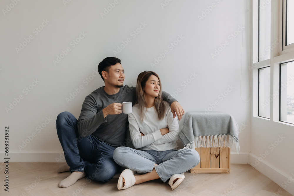 Happy romantic asian couple lover support with hug and coffee sit on the floor.