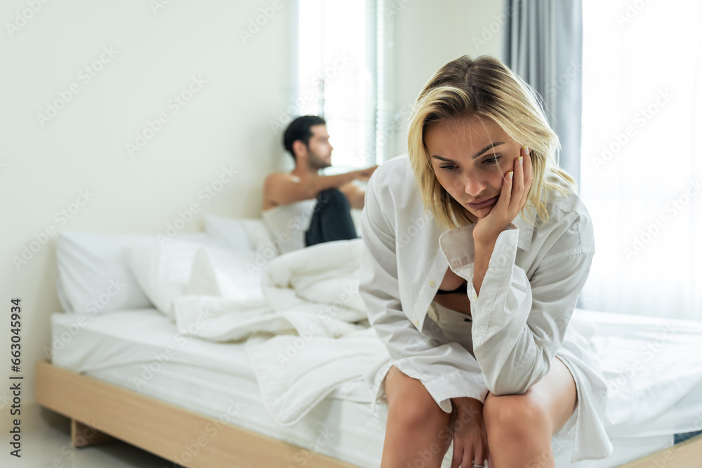 Caucasian young couple sitting on bed with painful after fight argument. Caucasian young couple sitting on bed with painful after fight argument.