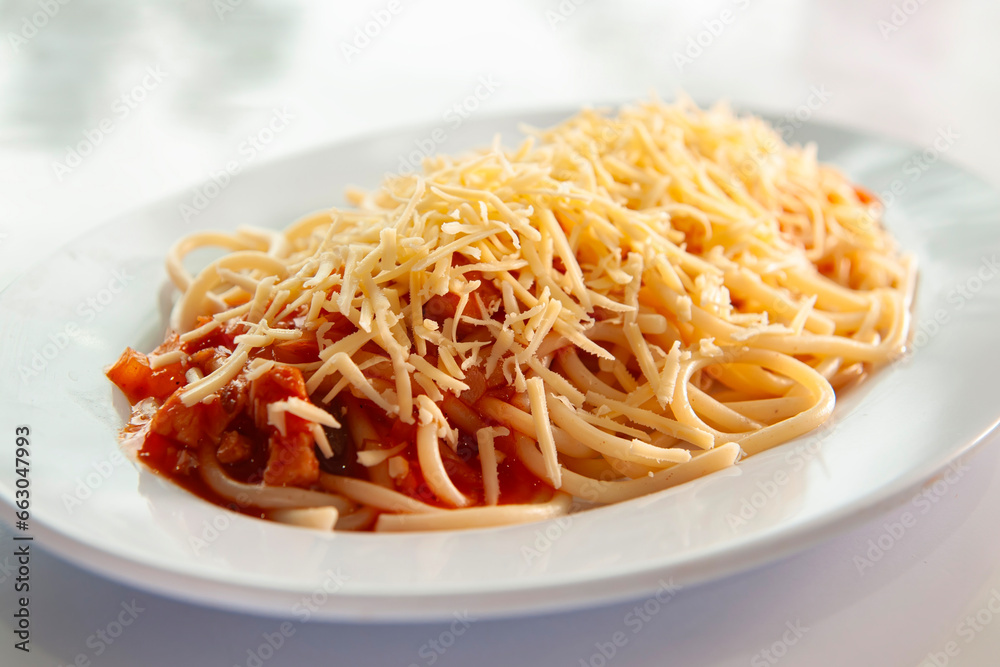 spaghetti bolognese with cheese sprinkled is placed on a white plate with a white background spaghetti bolognese with cheese sprinkled is placed on a white plate with a white background