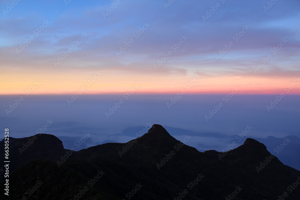 The three cone shape mountains and sunrise sky at Adam's Peak, Sri Lanka