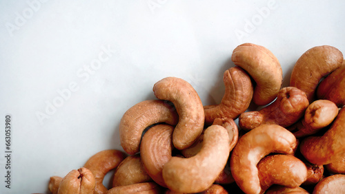 Top view pile heap of Roasted Cashew nuts isolated on white background, healthy vegetarian snack food, flat lay with copy space
