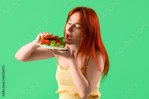Young redhead woman eating ...