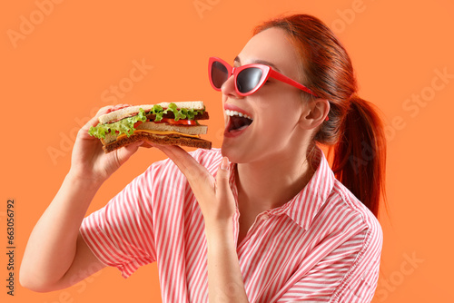 Young redhead woman eating ...