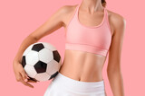 Beautiful young sporty woman with soccer ball on pink background, closeup