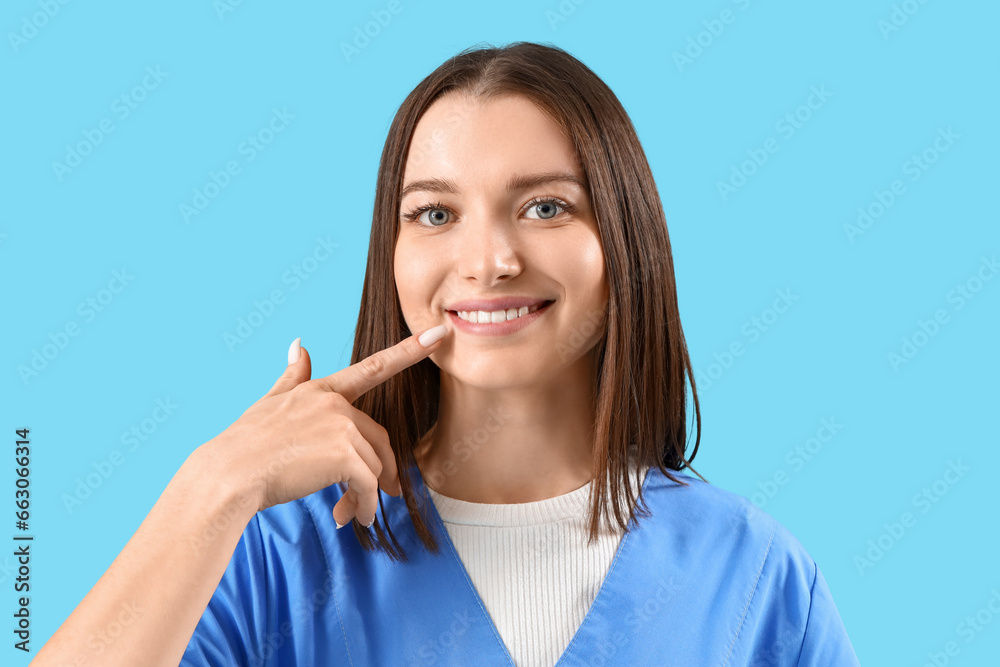 Smiling female dentist on blue background, closeup Smiling female dentist on blue background, closeup