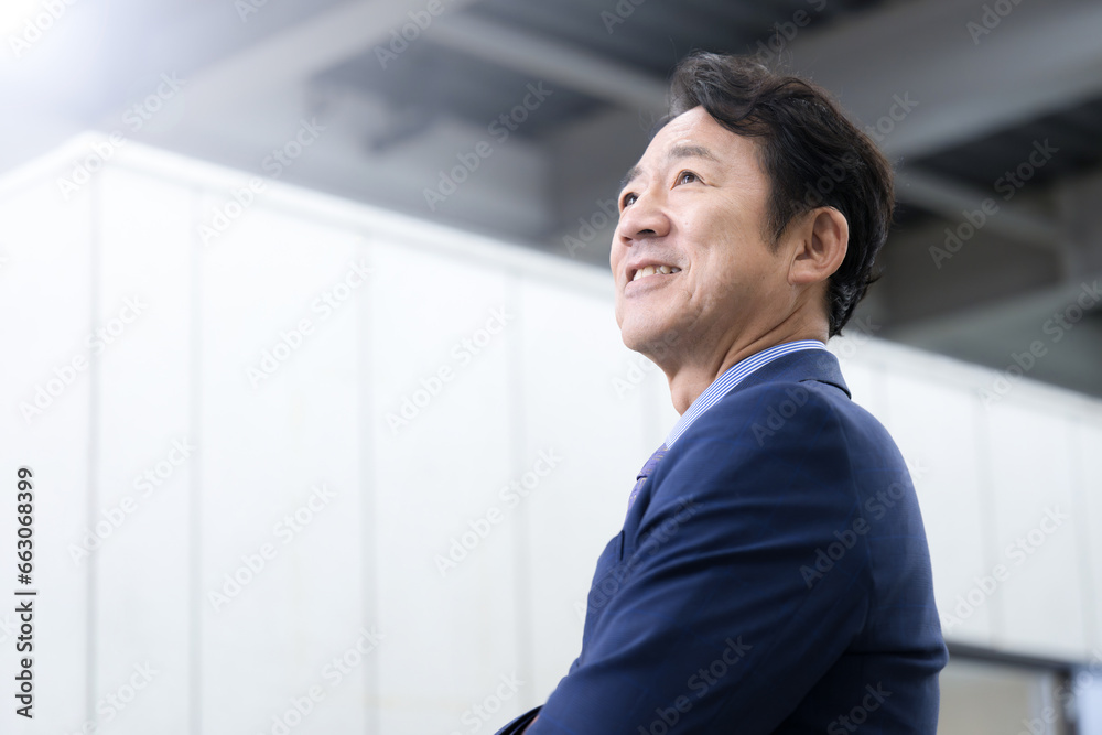 腕組みをする笑顔のシニア男性 未来や希望を見つめる社長や経営者のクローズアップ 左にコピースペース 腕組みをする笑顔のシニア男性 未来や希望を見つめる社長や経営者のクローズアップ 左にコピースペース