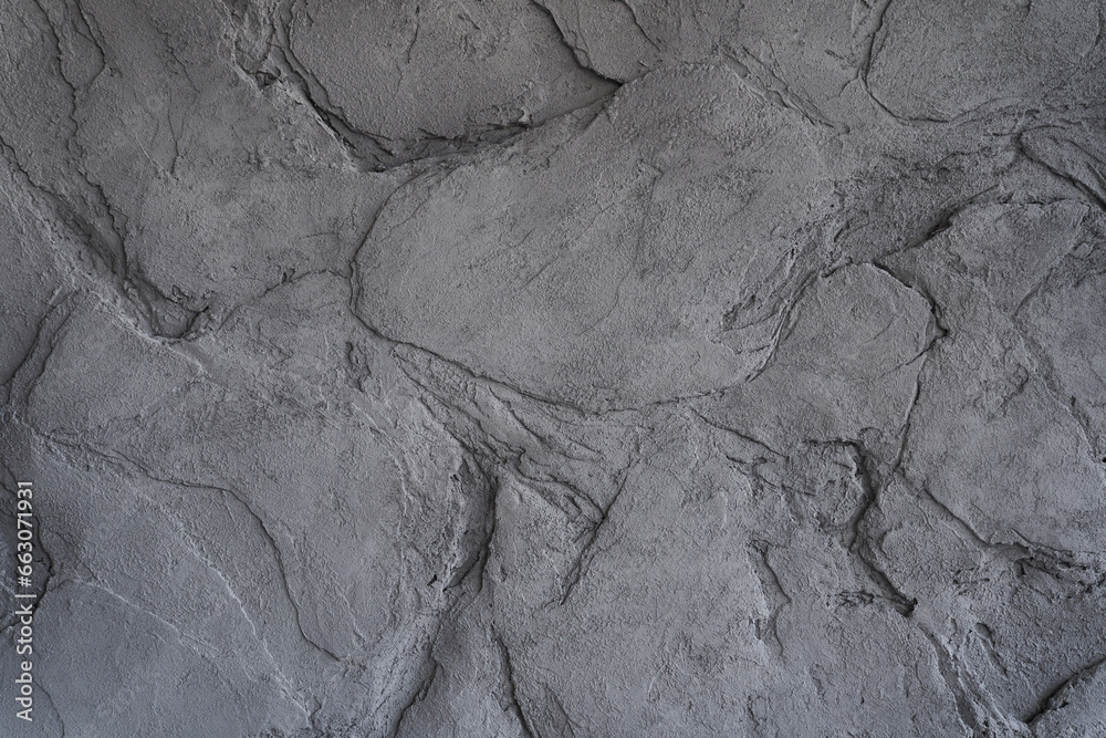 Fototapeta premium The gray texture of the stone. The cracked layered surface of the mountain. Close-up. Grey stone background with space to copy. High quality photo