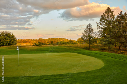 The perfect golf green with a white flag at sunset on course near Minnesota Minnesota USA
