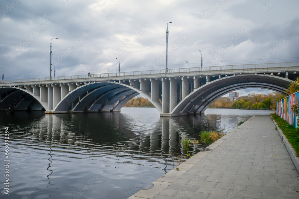 Modern river arch bridge on an autumn day Modern river arch bridge on an autumn day