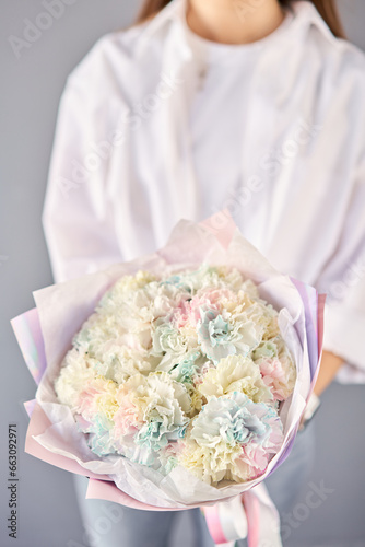 Beautiful Rainbow mono bouquet of flowers in woman hand. Floral shop concept . Beautiful fresh cut bouquet. Flowers delivery